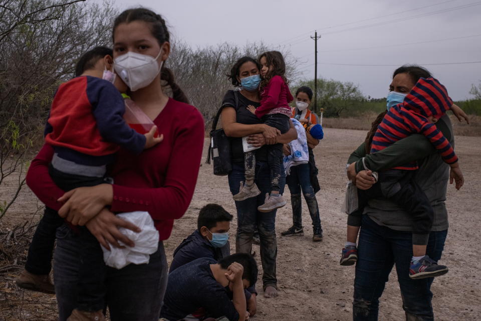 Asylum seeking migrant mothers from Central America hold their children as they await transport after crossing the Rio Grande river into the United States from Mexico on a raft in La Joya, Texas, U.S., March 14, 2021. (Adrees Latif/Reuters)