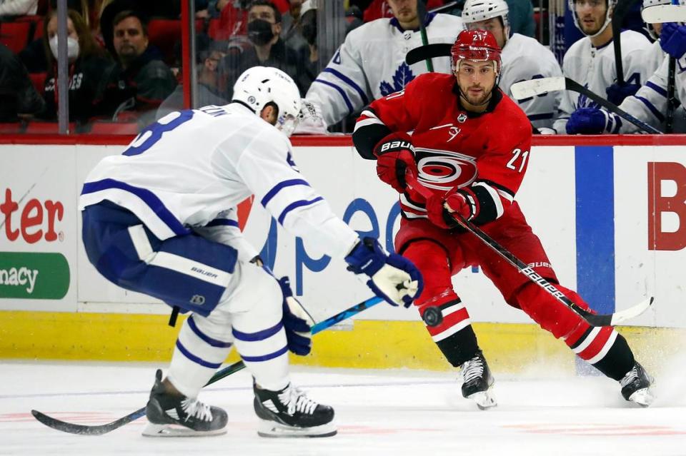 Carolina Hurricanes’ Nino Niederreiter (21) clears the puck past Toronto Maple Leafs’ Jake Muzzin (8) during the second period of an NHL hockey game in Raleigh, N.C., Monday, Oct. 25, 2021. (AP Photo/Karl B DeBlaker)