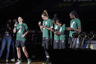 Seattle Storm's Sue Bird, left, speaks to fans as teammates Breanna Stewart, Jewell Loyd, Jordin Canada and Ezi Magbegor eye their new championship rings during a brief ceremony before a WNBA basketball game against the Las Vegas Aces, Saturday, May 15, 2021, in Everett, Wash. (AP Photo/Elaine Thompson)