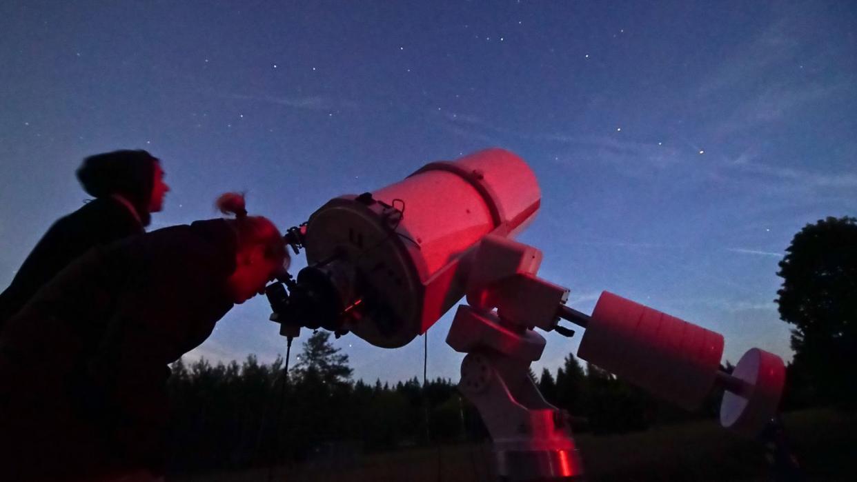 Das Archivfoto zeigt Sternegucker mit einem Teleskop.
