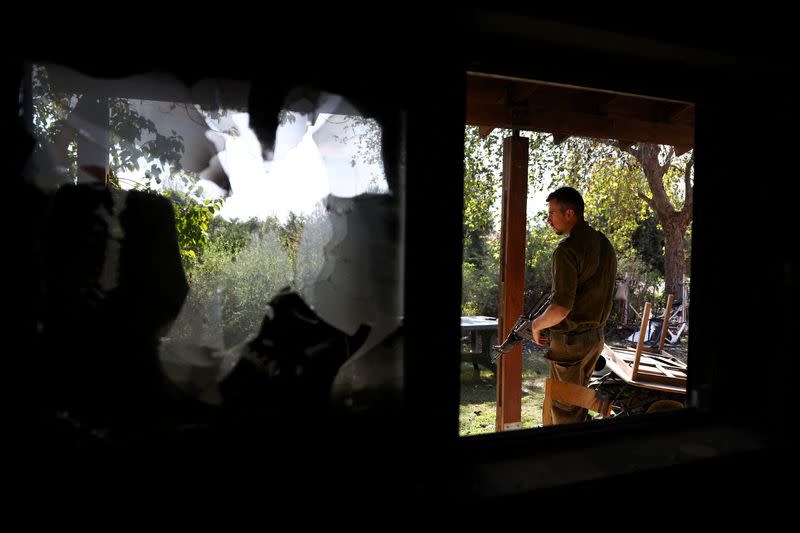 Un soldado israelí inspecciona una casa quemada que ha estado abandonada durante dos meses tras el mortífero ataque del 7 de octubre perpetrado por hombres armados del grupo miliciano palestino Hamás desde la Franja de Gaza, en el kibutz Beeri, en el sur de Israel