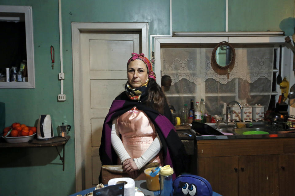 Cristina Aron, a Mapuche cultural liaison, poses for a photo in the kitchen of her home in Osorno, Chile, Sunday, Aug. 21, 2022. “Childbirth is a spiritual energy event for the mother, the baby and the community,” Aron says. (AP Photo/Luis Hidalgo)