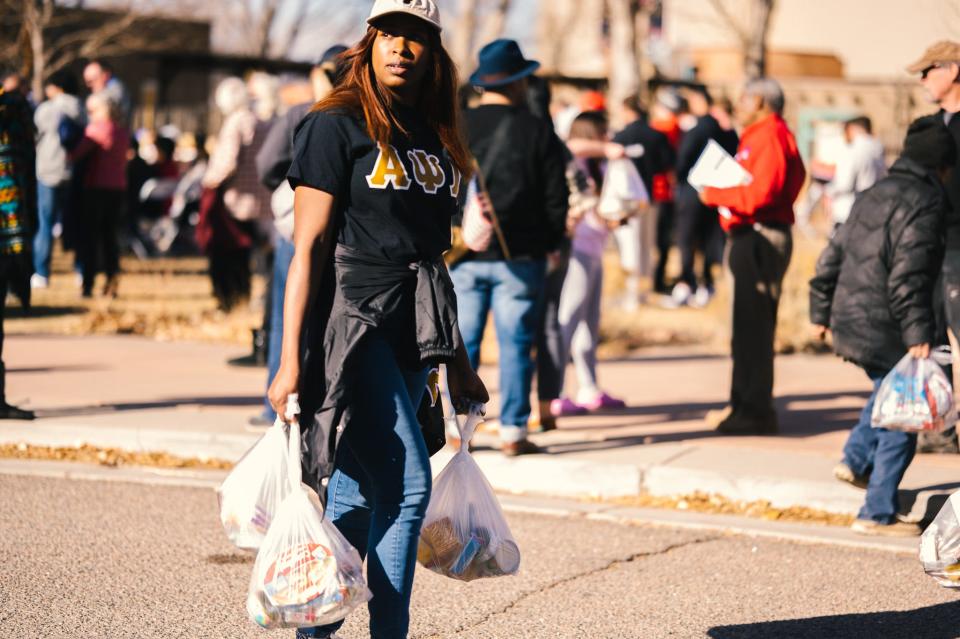A volunteer from Colorado State University Pueblo participates in a food drive as part of Pueblo's celebration of Martin Luther King Jr. Day in 2023.