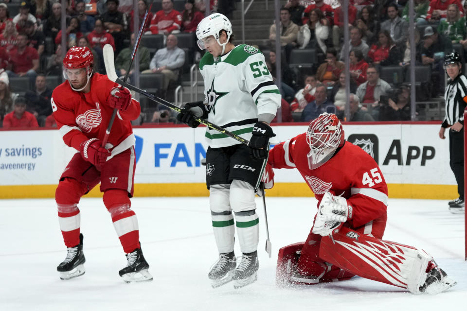 Dallas Stars center Wyatt Johnston (53) tries to screen Detroit Red Wings goaltender Magnus Hellberg (45) as Ben Chiarot (8) defends in the first period of an NHL hockey game Monday, April 10, 2023, in Detroit. (AP Photo/Paul Sancya)