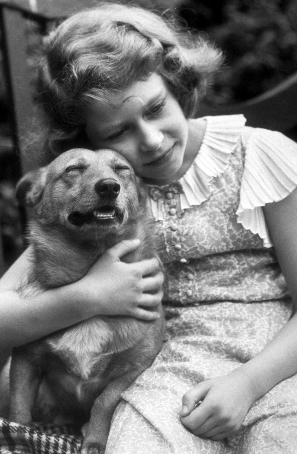 Juli 1936: Prinzessin Elizabeth kuschelt mit einem Corgi Bild: Lisa Sheridan/Studio Lisa/Hulton Archive/Getty Images)