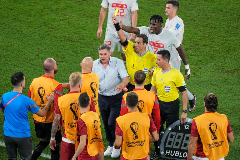 Fernando Rapallini le muestra la tarjeta amarilla a uno de los jugadores suplentes de Serbia que invadieron el campo de juego para reclamar un penal.