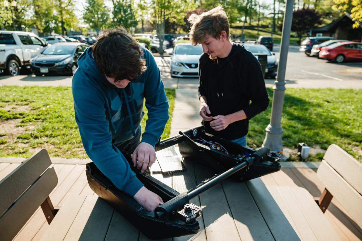 Kent State University at Tuscarawas engineering students Hayden Dixson, left, and Braden Harris prepare their group capstone water skimmer for demonstration earlier this month at the Tuscora Park Pond in New Philadelphia.