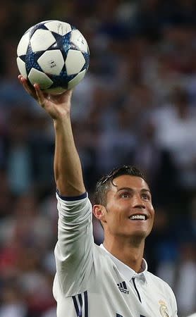 Foto del martes del delantero del Real Madrid Cristiano Ronaldo celebrando su tripleta con el balón del partido tras la victoria sobre Bayern Munich. 18/4/17 El Real Madrid venció 4-2 al Bayern Munich el martes en un partido que se decidió en el alargue y con un triplete del portugués Cristiano Ronaldo, sumándose así a su clásico rival Atlético Madrid en alcanzar las semifinales de la Liga de Campeones. Reuters / Sergio Perez