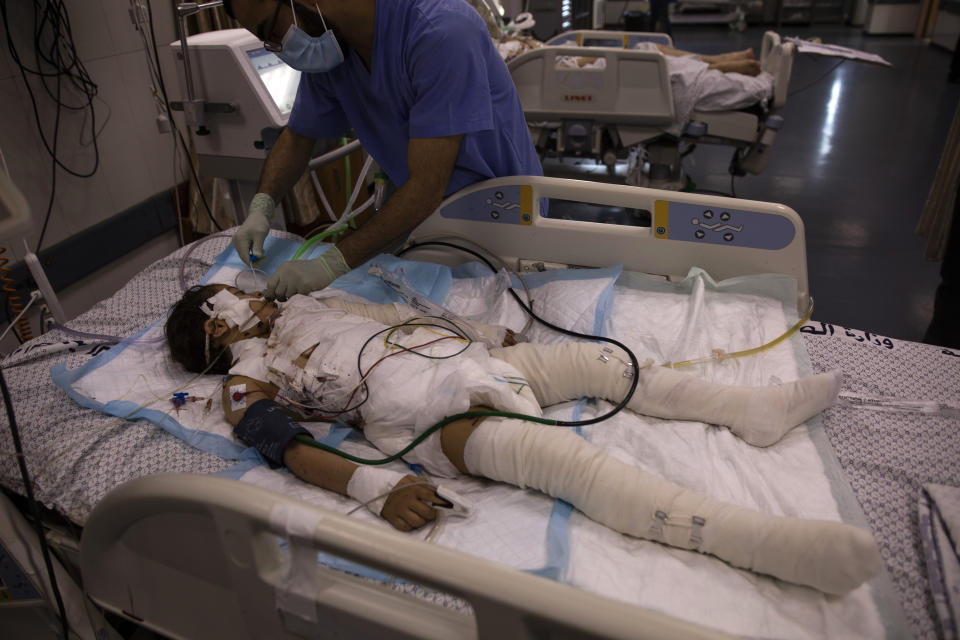 A Palestinian medic gives treatment to a wounded girl in the ICU of the Shifa hospital, Thursday, May 13, 2021, in Gaza City. She was injured by a May 12 Israeli strike that hit her family house. Just weeks ago, the Gaza Strip’s feeble health care system was struggling with a runaway surge of coronavirus cases. Now doctors across the crowded coastal enclave are trying to keep up with a very different crisis: blast and shrapnel wounds, cuts and amputations. (AP Photo/Khalil Hamra)