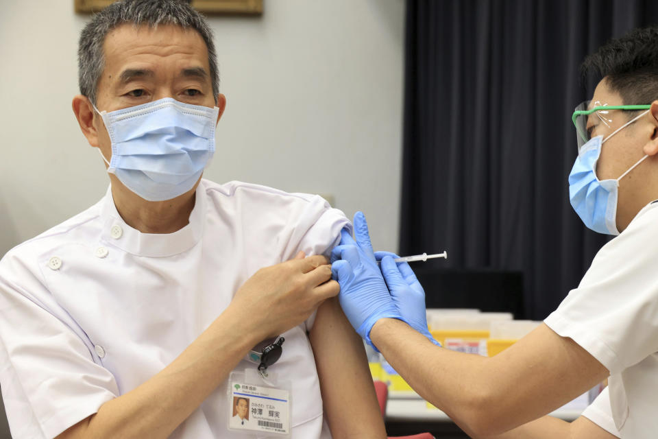 Terumi Kamisawa, left, president of Tokyo Metropolitan Cancer and Infectious Center Komagome Hospital receives a dose of a Pfizer COVID-19 vaccine at the hospital in Tokyo Friday, March 5, 2021. Japan's government will extend a state of emergency in the Tokyo region for another two weeks because its medical systems are still strained by COVID-19 patients, the minister in charge of virus response said Friday. (Yoshikazu Tsuno/Pool Photo via AP)