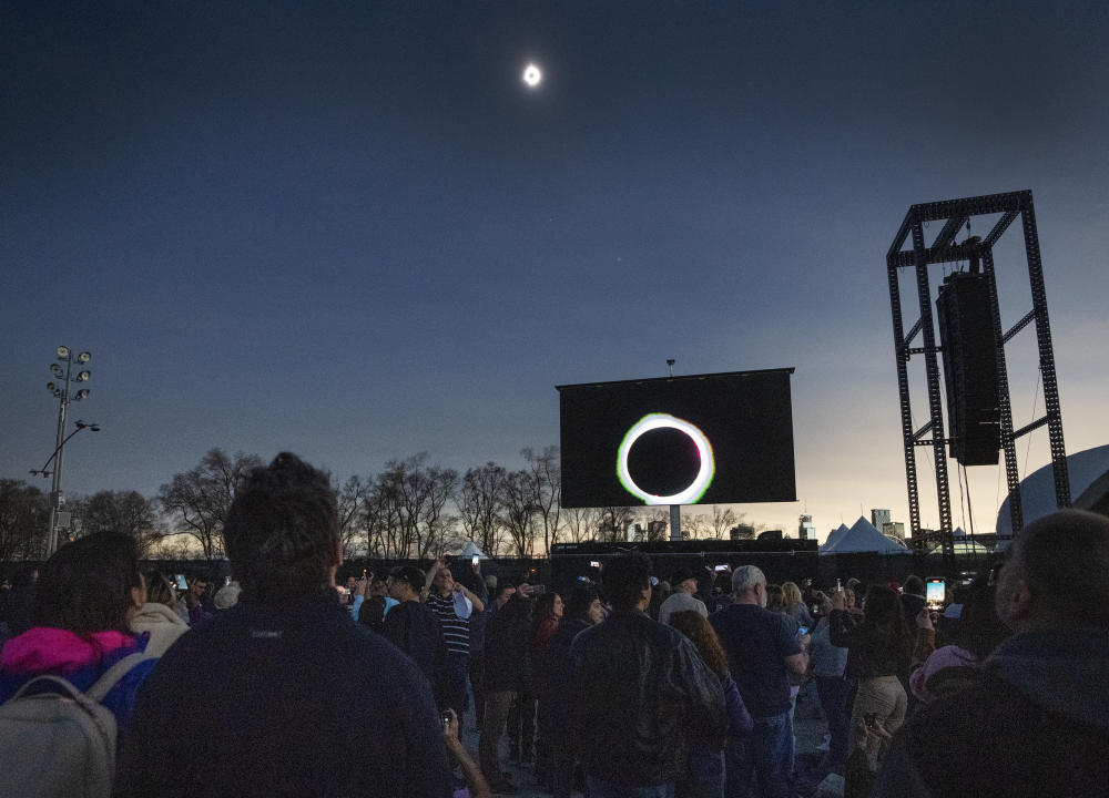 People watch the totally phase of a total solar eclipse at Parc Jean Drapeau, in Montreal, Monday, April 8, 2024. THE CANADIAN PRESS/Ryan Remiorz