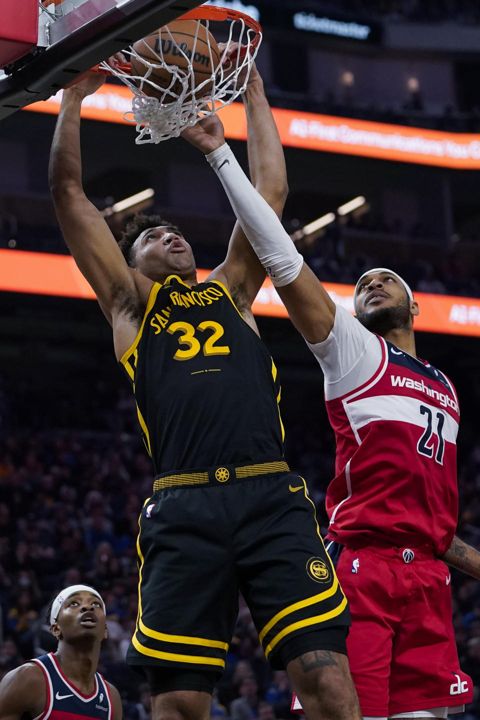Golden State Warriors forward Trayce Jackson-Davis, left, dunks while defended by Washington Wizards center Daniel Gafford during the first half of an NBA basketball game Friday, Dec. 22, 2023, in San Francisco. (AP Photo/Godofredo A. Vásquez)