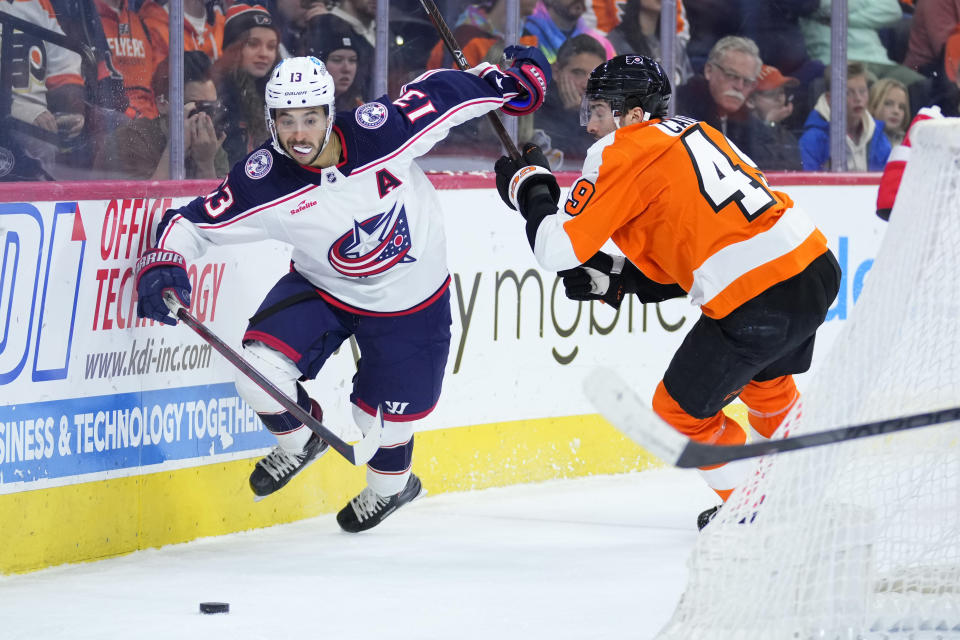 Columbus Blue Jackets' Johnny Gaudreau, left, tries to get past Philadelphia Flyers' Noah Cates during the third period of an NHL hockey game, Tuesday, Dec. 20, 2022, in Philadelphia. (AP Photo/Matt Slocum)