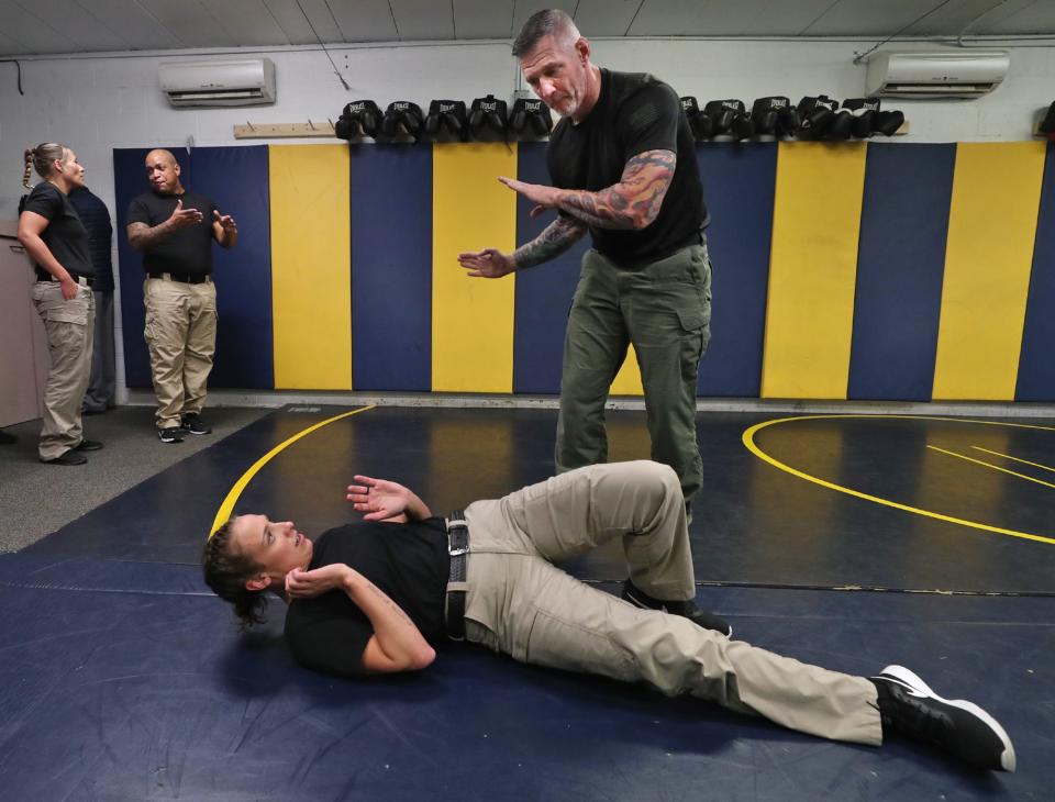 Brian Boss, Akron Police Department training officer, instructs police cadet Morgan Muster as she practices a self defense movement during a media day at the Akron Police Training Academy on March 14.