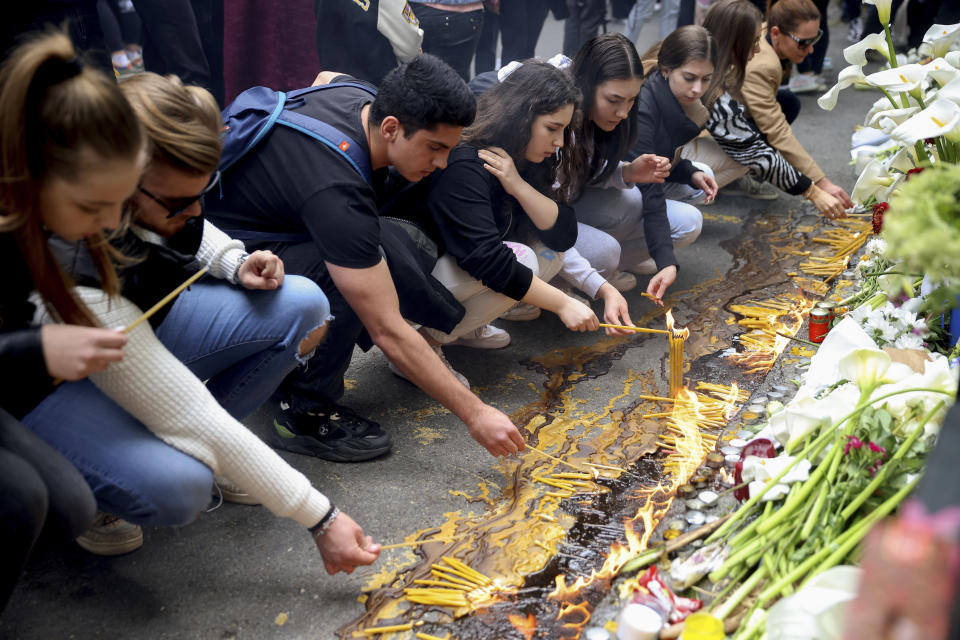School children light candles near the Vladislav Ribnikar school in Belgrade, Serbia, Thursday, May 4, 2023. Many wearing black and carrying flowers, scores of Serbian students on Thursday paid silent homage to their peers killed a day earlier when a 13-year-old boy used his father’s guns in a school shooting rampage that sent shock waves through the nation and triggered moves to boost gun control. (AP Photo/Armin Durgut)