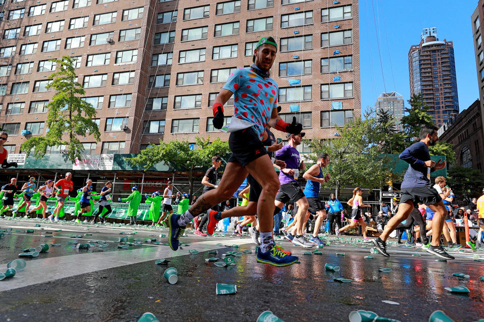 Runners pass discarded cups on First Avenue during the 2019 TCS New York City Marathon, Nov. 3, 2019 in New York City. (Photo: Gordon Donovan/Yahoo News)