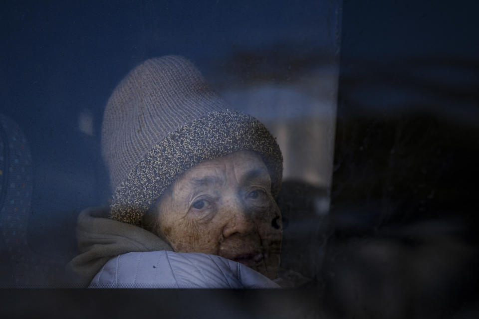 A refugee fleeing the war from neighboring Ukraine looks out a bus window after crossing the border, at the Romanian-Ukrainian border, in Siret, Romania, Monday, March 14, 2022. (AP Photo/Andreea Alexandru)