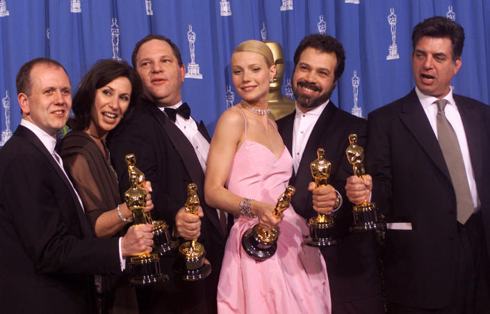FILE - From left, David Parfitt, Donna Gigliotti, Harvey Weinstein, Gwyneth Paltrow, Edward Zwick and Marc Norman all celebrate after receiving the Oscar for best picture for "Shakespeare In Love" during the 71st Annual Academy Awards Sunday, March 21, 1999, at the Dorothy Chandler Pavilion of the Los Angeles Music Center. Paltrow won the Oscar for best actress in the movie. (AP Photo/Dave Caulkin, File)
