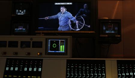 Opera Singer Simon O'Neill playing the role of Parsifal appears on a screen in the sound room during a live broadcast of the opera "Parsifal" from the Royal Opera House in London December 18, 2013. REUTERS/Suzanne Plunkett