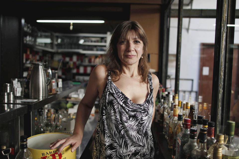 WITH STORY GREECE VOICES BY NIKOS PAPHITIS : Dina Bika, 44, poses behind the counter of her coffee-bar in the Psyrri district of central Athens, on Thursday, Aug. 23, 2012. As Greek Prime Minister Antonis Samaras sets off around Europe to plead for more time to achieve the country’s tough reform targets, austerity-weary Greeks are bracing for new pain but mostly expect to stay in the 17-nation eurozone, come what may. Bika, whose custom has dropped 80 percent in the past few years, said she expects Greece to leave the currency union “sooner or later,” and new planned cutbacks will just delay the inevitable. “Going back to the drachma would not be the worst thing that could happen to us, it would teach us to function in a more responsible way, both as individuals and as a state,” she said.(AP Photo/Petros Giannakouris)