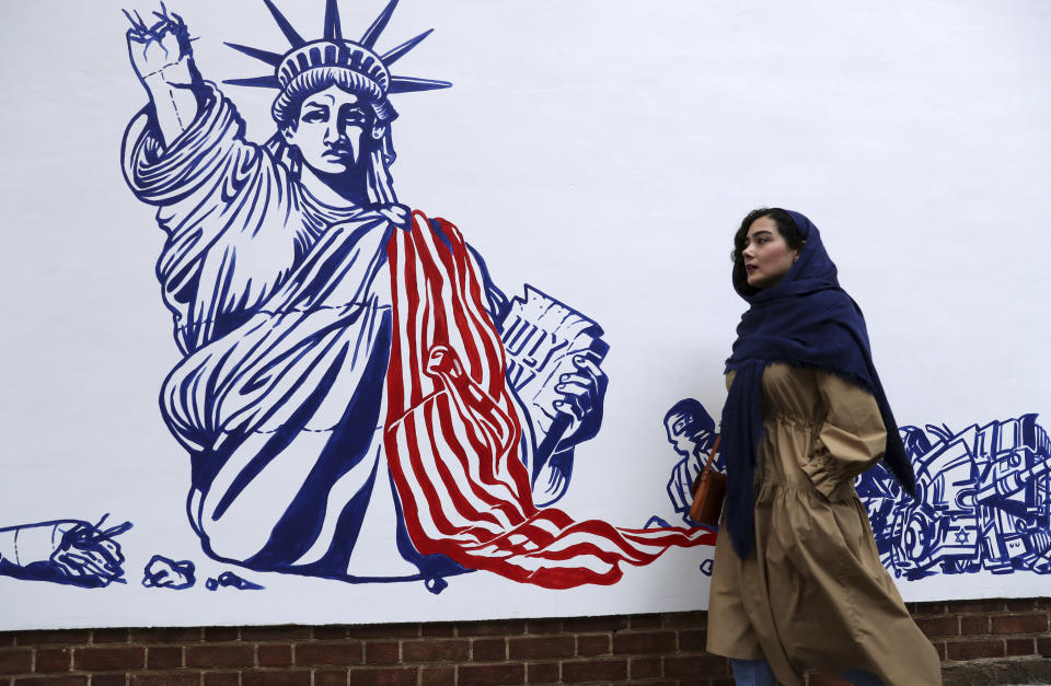 A woman walks past a satirical drawing of the Statue of Liberty after new anti-U.S. murals on the walls of former U.S. embassy unveiled in a ceremony in Tehran, Iran, Saturday, Nov. 2, 2019. Anti-U.S. works of graphics is the main theme of the wall murals painted by a team of artists ahead of the 40th anniversary of the takeover of the U.S. diplomatic post by revolutionary students. (AP Photo/Vahid Salemi)