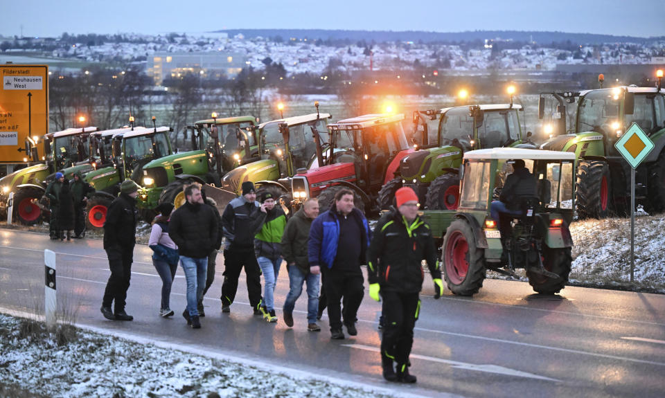 Farmers block the access road to the A8 highway with tractors in Neuhausen, Monday, Jan. 8, 2024. Farmers blocked highway access roads in parts of Germany Monday and gathered for demonstrations, launching a week of protests against a government plan to scrap tax breaks on diesel used in agriculture.(Bernd Wei'brod/dpa via AP)