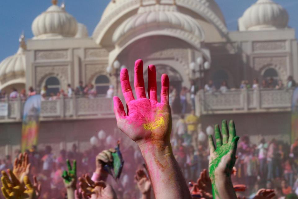 Revelers with colored corn starched hands celebrate during the 2014 Festival of Colors, Holi Celebration at the Krishna Temple Saturday, March 29, 2014, in Spanish Fork, Utah. Nearly 70,000 people are expected to gather starting Saturday at a Sri Sri Radha Krishna Temple in Spanish Fork for the annual two-day festival of colors. Revelers gyrate to music and partake in yoga during the all-day festival, throwing colored corn starch in the air once every hour. The Salt Lake Tribune reports that the large majority of participants are not Hindus, but Mormons. Thousands of students from nearby Brigham Young University come to take part in a festival that is drug and alcohol free. The event stems from a Hindu tradition celebrating the end of winter and the triumph of good over evil. (AP Photo/Rick Bowmer)