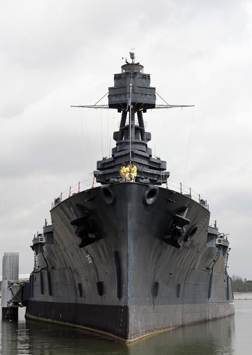 Tourists visit the deck of the USS Texas as she lists slightly on the port side Wednesday, June 13, 2012, in Houston. The 100-year-old battleship's hull sprung a leak five days ago and she has been taking on as much as 1,000 gallons of seawater every minute as workers struggle to contain it. (AP Photo/Pat Sullivan)