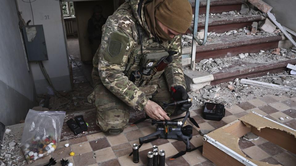 A Ukrainian soldier equips a drone with grenades in the Donetsk region on March 15, 2023. (Roman Chop/AP)