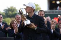 Jun 25, 2017; Cromwell, CT, USA; Jordan Spieth kisses the Championship trophy after a victory in the first playoff hole during the final round of the Travelers Championship golf tournament at TPC River Highlands. Mandatory Credit: Bill Streicher-USA TODAY Sports