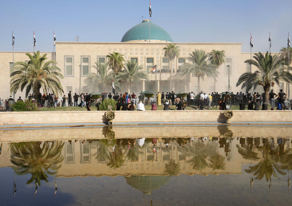 Iraqi security forces fire tear gas on the followers of Shiite cleric Muqtada al-Sadr inside the government Palace, Baghdad, Iraq, Monday, Aug. 29, 2022. Al-Sadr, a hugely influential Shiite cleric announced he will resign from Iraqi politics and his angry followers stormed the government palace in response. The chaos Monday sparked fears that violence could erupt in a country already beset by its worst political crisis in years. (AP Photo/Hadi Mizban)