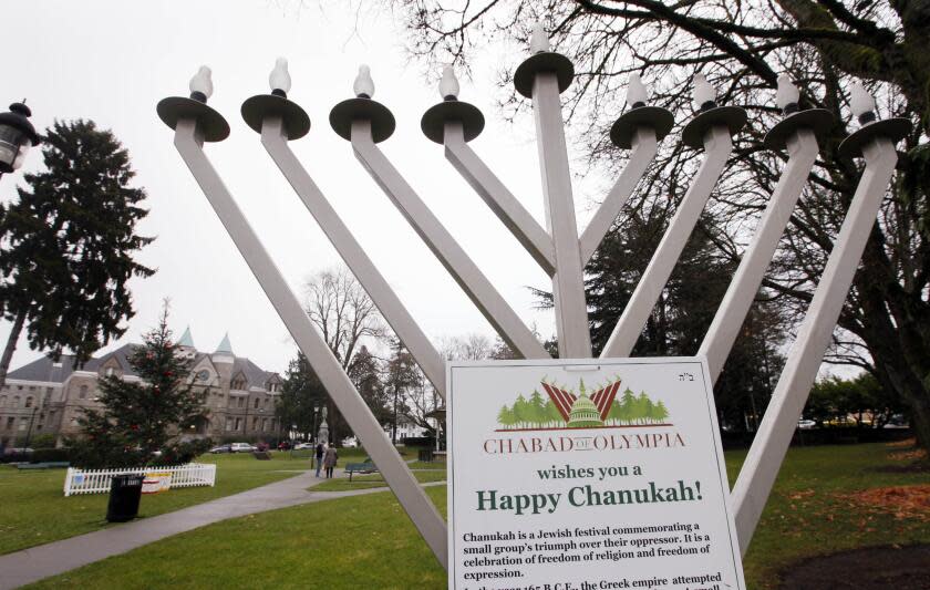 A menorah stands in a public park and in view of a nearby "holiday tree" in a public park not far from the Capitol campus Wednesday, Dec. 21, 2011, in Olympia, Wash. The holiday displays that have previously competed for attention on the state's Capitol campus are now co-existing peacefully. A Nativity scene was set up a couple of hundred feet away from a display that declares "there are no gods." State officials have been grappling in recent years with how to balance the First Amendment issues of religion and free speech. In 2008, displays within the Capitol escalated into a controversy and the state eventually declared a moratorium on the exhibits. (AP Photo/Elaine Thompson)