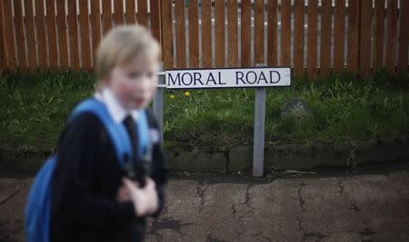 A boy passes a broken sign for Balmoral Road, the street where the former Johnnie Walker plant was located in Kilmarnock, Scotland March 25, 2014. The plant, which was Kilmarnock's largest employer, closed in 2012. REUTERS/Suzanne Plunkett