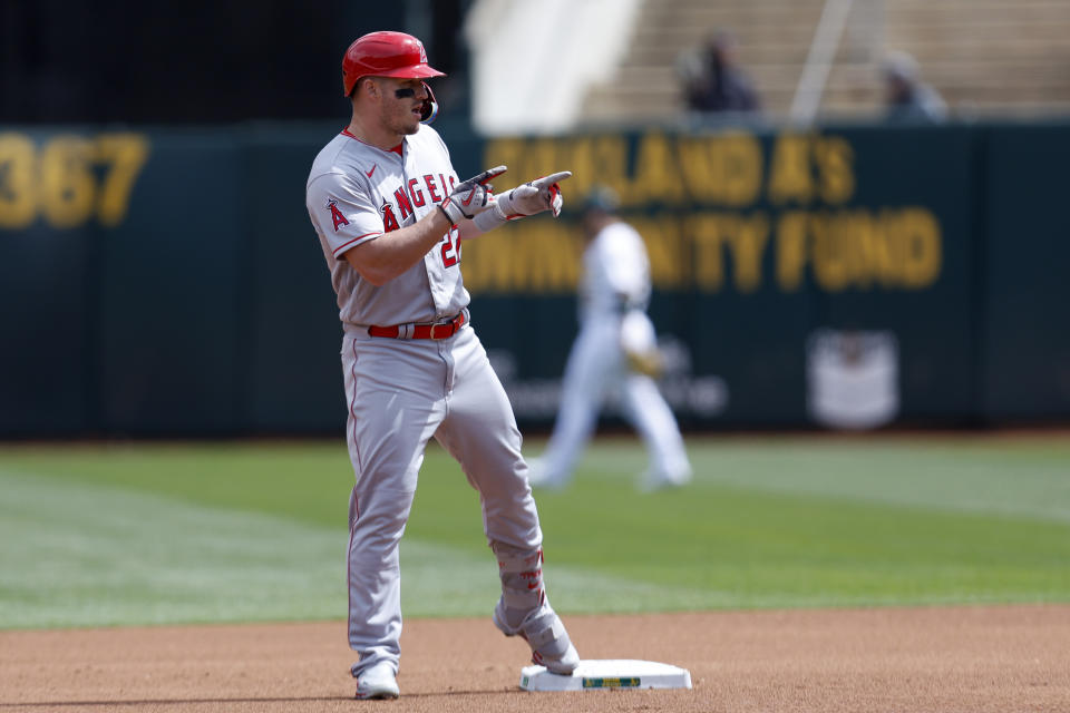 Los Angeles Angels' Mike Trout (27) gestures to his teammates after hitting a double during the first inning of a baseball game against the Oakland Athletics in Oakland, Calif., Sunday, April 2, 2023. (AP Photo/Jed Jacobsohn)