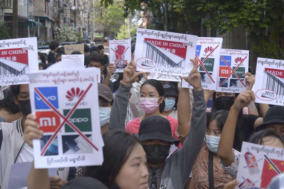 Anti-coup protesters hold slogans calling for a boycott of Chinese products during a demonstration in Yangon, Myanmar on Wednesday, April 7, 2021. Protesters continue to hold daily demonstrations in some parts of Myanmar despite threats from government forces of arrest and dispersal as they rally against the Feb. 1 military coup that ousted the civilian government of Aung San Suu Kyi. (AP Photo)