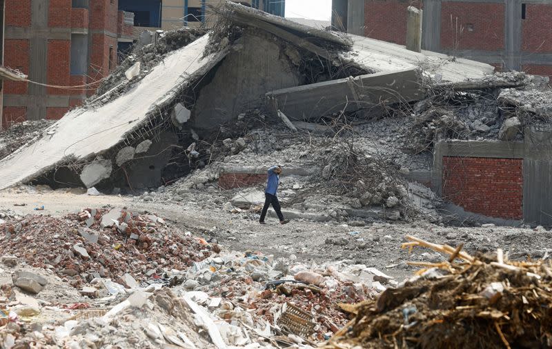 A man passes destructed buildings in Banha city, Al Qalyubia Governorate, north of Cairo