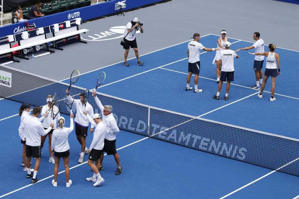 The Springfield Lasers, left, and Orlando Storm, right, are introduced at the start of the World Teamtennis tournament at an empty tennis arena at The Greenbrier Resort Sunday July 12, 2020, in White Sulphur Springs, W.Va. (AP Photo/Steve Helber)