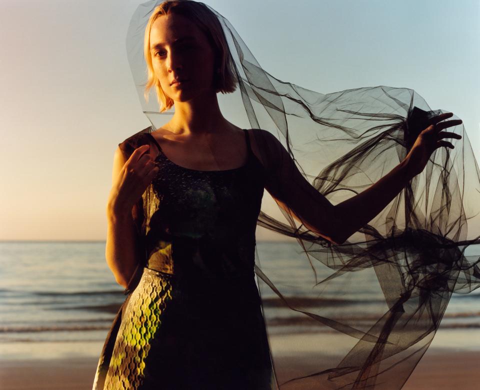 “I think people know not to ask me certain things. They’re not going to know who I’m going out with.” Here she wears a Prada duchesse satin dress, its tulle overlay smoky and ethereal in the sunset.