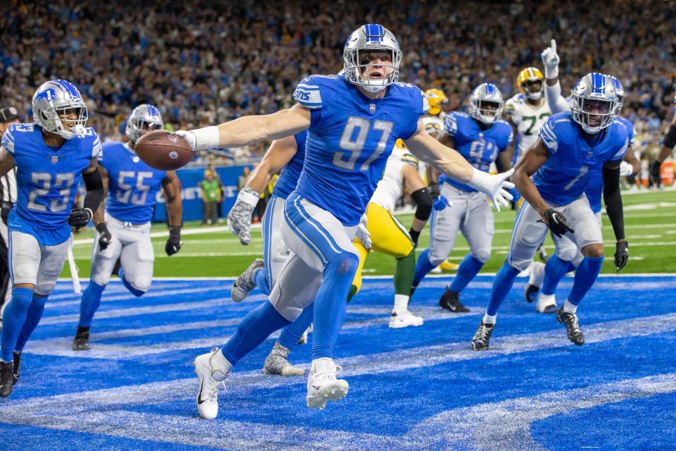 Detroit Lions defensive end Aidan Hutchinson (97) celebrates his interception during the second quarter against the Green Bay Packers at Ford Field.