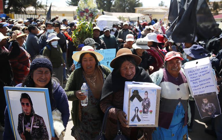 Familiares, amigos y residentes cargan ataúdes y fotos de los muertos por choques con la policía durante una procesión en Juliaca