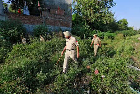 Police officials search for body parts next to a railway track track after a commuter train traveling at high speed ran through a crowd of people on the rail tracks on Friday, in Amritsar, India, October 20, 2018. REUTERS/Adnan Abidi