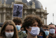 A portrait of Samuel Paty is held up as people gather on Republique square in Lille, northern France, Sunday Oct. 18, 2020. Demonstrators in France on Sunday took part in gatherings in support of freedom of speech and in tribute to a history teacher who was beheaded near Paris after discussing caricatures of Islam’s Prophet Muhammad with his class. (AP Photo/Michel Spingler)