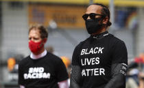 Ferrari driver Sebastian Vettel of Germany, left, and Mercedes driver Lewis Hamilton of Britain, wearing a Black Lives Matter shirt, stand against racism in the pit lane prior the Styrian Formula One Grand Prix race at the Red Bull Ring racetrack in Spielberg, Austria, Sunday, July 12, 2020. (Mark Thompson/Pool via AP)