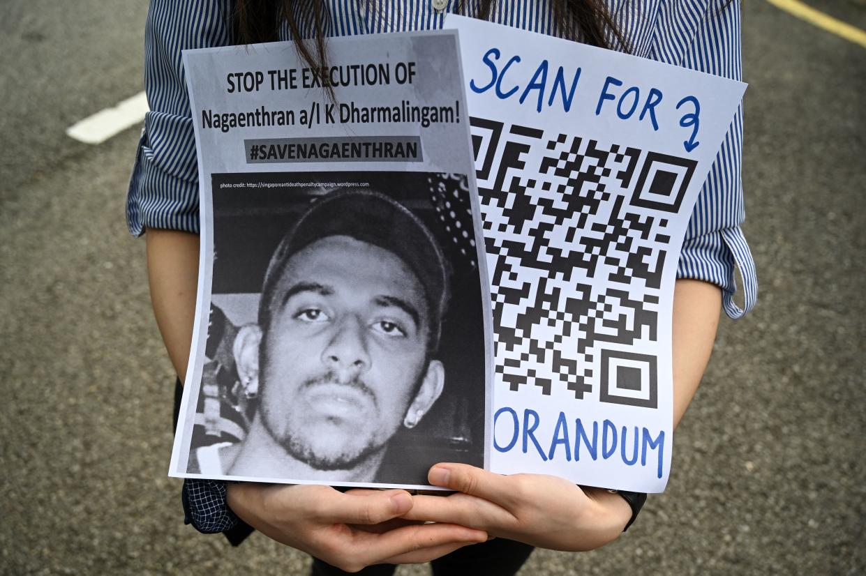 An activist holds a placard before submitting a memorandum to parliament in protest at the impending execution of Nagaenthran K. Dharmalingam, sentenced to death for trafficking heroin into Singapore, in Kuala Lumpur on November 3, 2021. (Photo by Mohd RASFAN / AFP) (Photo by MOHD RASFAN/AFP via Getty Images)