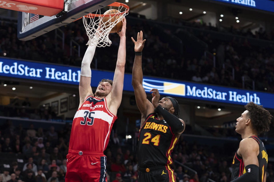 Washington Wizards' Mike Muscala (35) goes for a basket as Atlanta Hawks' Bruno Fernando (24) tries to block during the first half of an NBA basketball game Sunday, Dec. 31, 2023, in Washington. (AP Photo/Jose Luis Magana)