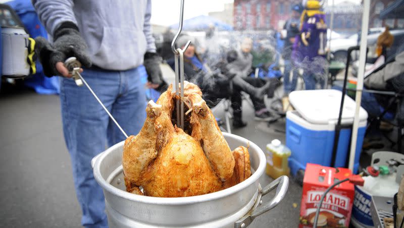 A tailgater deep-fries a turkey at Eastern Market before an NFL football game between the Detroit Lions and the Minnesota Vikings on Nov. 24, 2016, in Detroit.