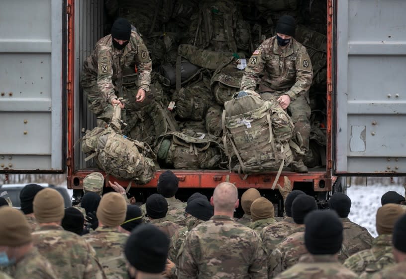 FORT DRUM, NEW YORK - DECEMBER 10: U.S. Army soldiers retrieve their duffel bags after they returned home from a 9-month deployment to Afghanistan on December 10, 2020 at Fort Drum, New York. The 10th Mountain Division soldiers who arrived this week are under orders to isolate with family at home or with fellow troops in barracks, finishing their quarantine just before Christmas. In the waning days of the Trump Administration and after 19 years of war, the U.S. military continues to reduce troop levels in Afghanistan. (Photo by John Moore/Getty Images)