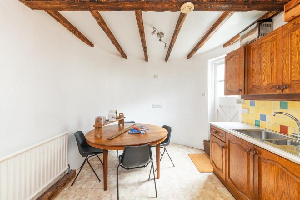 The ground floor kitchen features wooden beams, cupboards and table (Hive Estates)