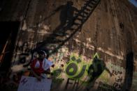 A demonstrator stands next to a graffiti reading "Revolution" during an anti-government protest in downtown Beirut