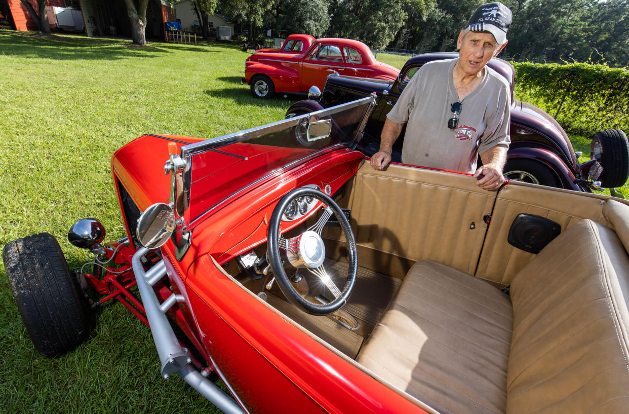 Dennis Darnell, a lifelong car collector and custom car builder, stands next to his 1932 Ford High Boy hot rod on July 29 outside his Ocala home. He used to own D&D Towing.